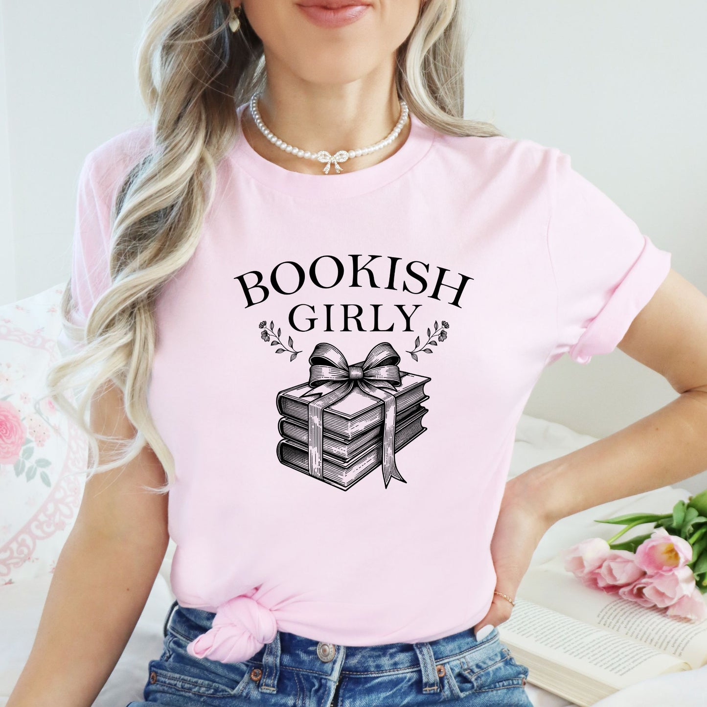 Person wearing a pink t-shirt with 'BOOKISH GIRLY' text and book graphic.
