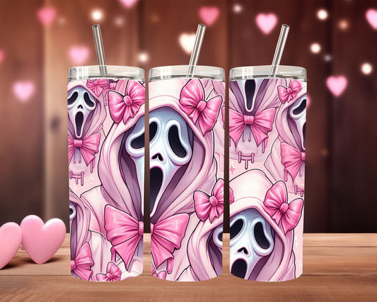 Three tumbler with ghost and pink bow design on a wooden surface with heart-shaped decorations.