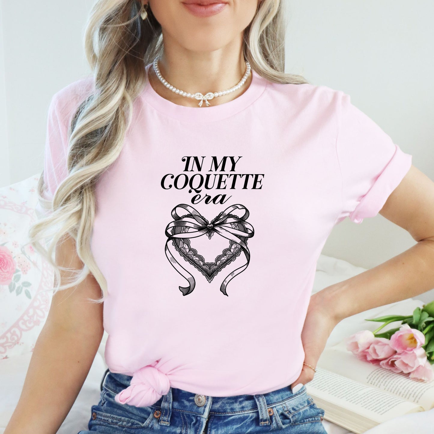 In my coquette era pink t-shirt model with black print of bow and heart print design