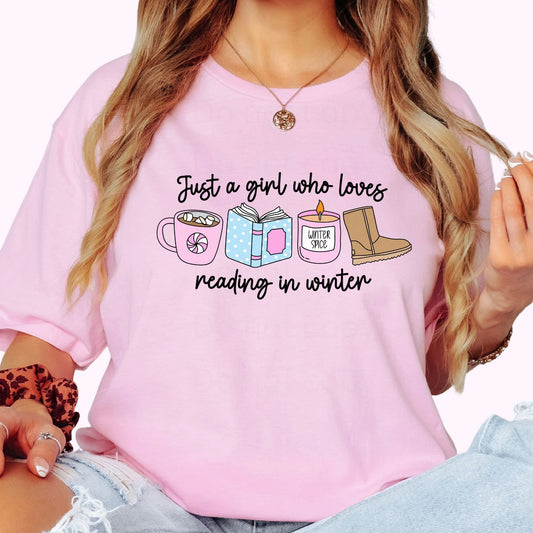 Person wearing a pink shirt with a graphic and text. Just a girl who loves reading in winter.